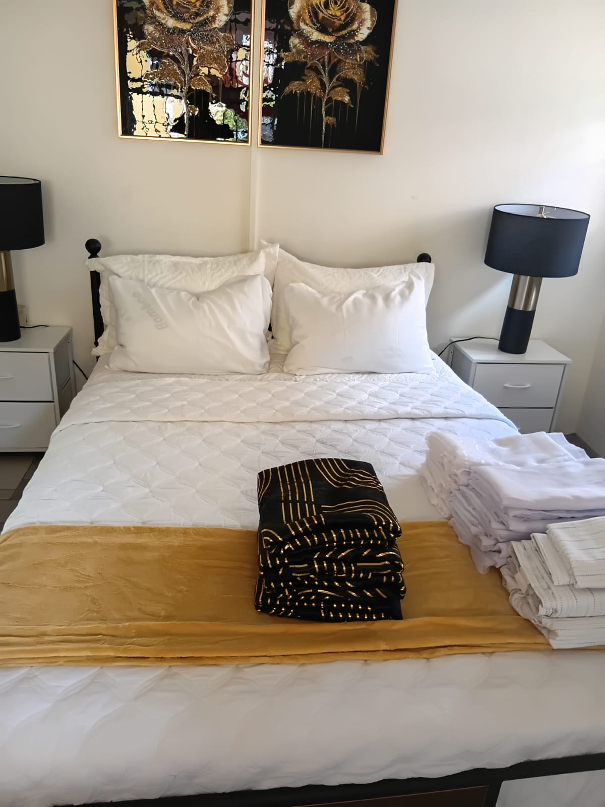 Main bedroom with gold accents and bedside lamps